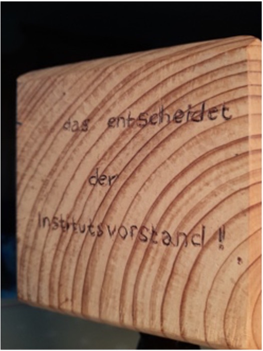 Holzwuerfel Das entscheidet der Institutsvorstand Seite eines Holzwürfels mit der Inschrift : Das entscheidet der Institutsvorstand!!